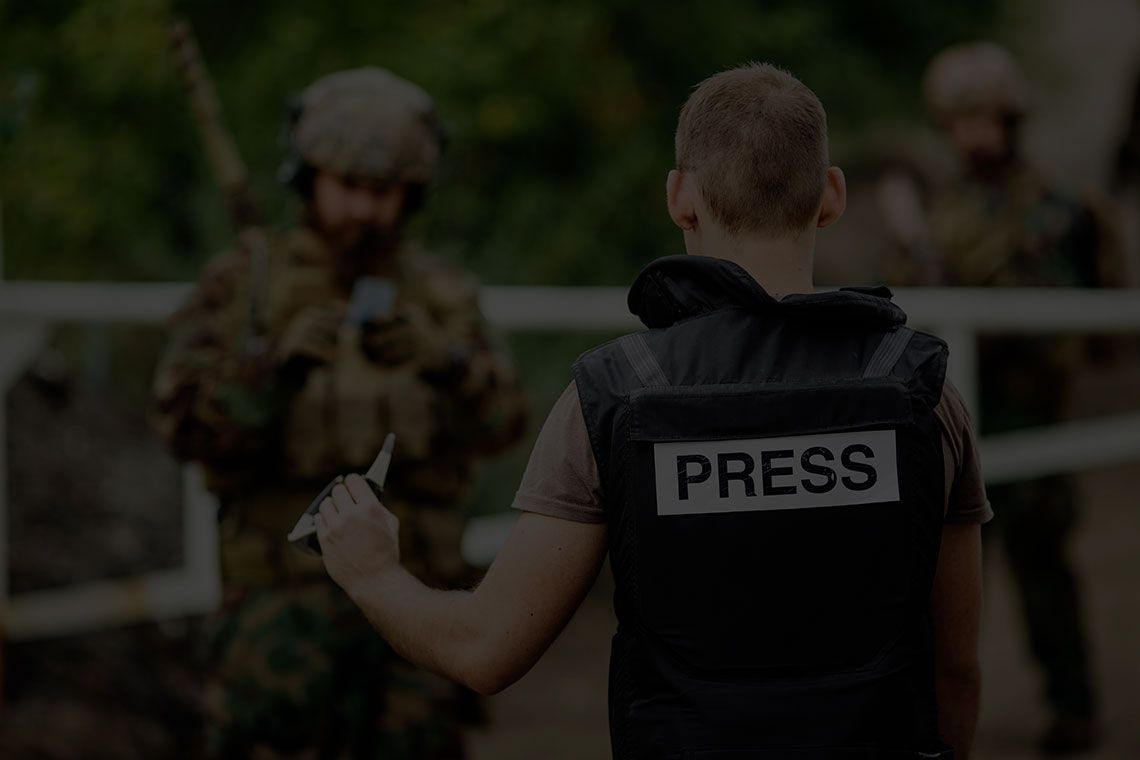 Журналист в бронежилете с шевроном PRESS показывает документы